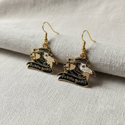 Pair of gold and black plague doctor earrings on a light background