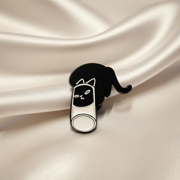 Black and white cat-shaped pin on a textured beige background
