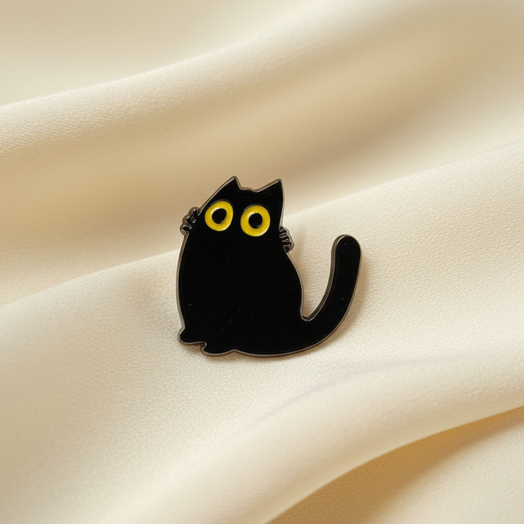Black cat-shaped object with yellow eyes on a light gray background
