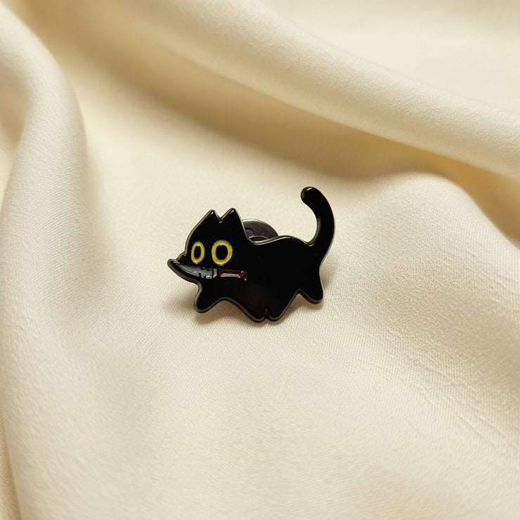 Black cat-shaped object with yellow eyes on a light gray background