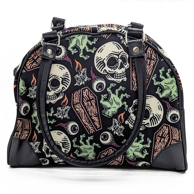 Gothic-style handbag with skull and candle design on a white background