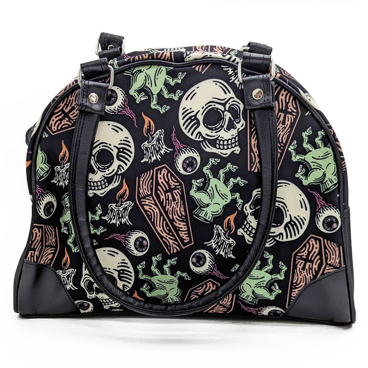 Gothic-style handbag with skull and candle design on a white background