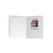 The interior of a greeting card. On white paper, the interior left side is blank. The interior right side has an illustration of a dumpster on fire, and the text below reads, "but maybe also you do therapy". 