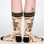 Socks with skeleton design worn by a person on a white background