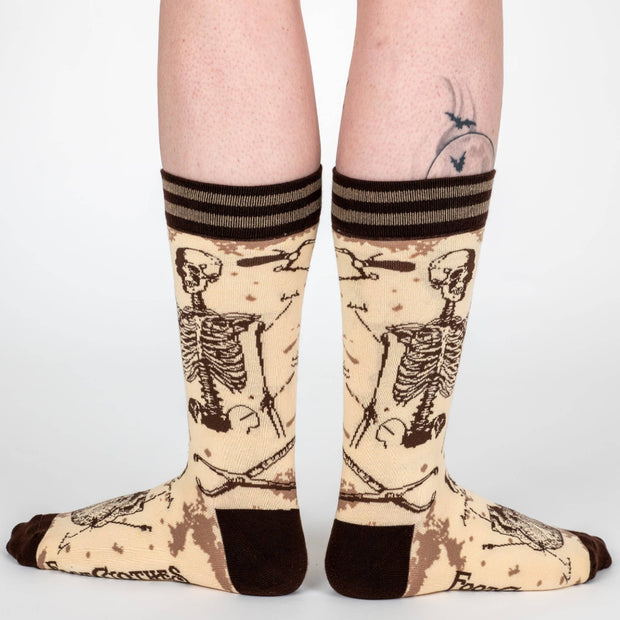 Socks with skeleton design worn by a person on a white background