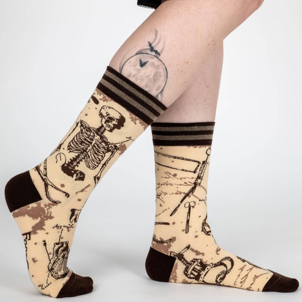 Socks with skeleton design worn by a person on a white background