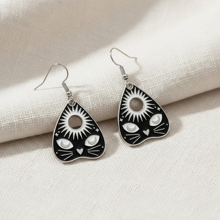 Pair of black and silver earrings on a gray background