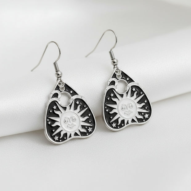 Pair of black and silver earrings on a gray background