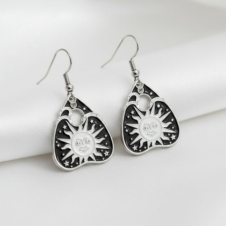 Pair of black and silver earrings on a gray background