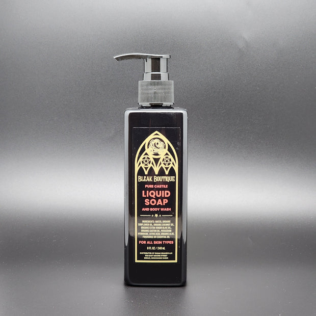 A black rectangular bottle of body wash with a pump top on a dark gray background
