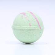 Green bath bomb with pink swirl on a white background