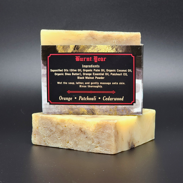 Bar of Burnt Year Handmade Bar Soap with a label on a dark background