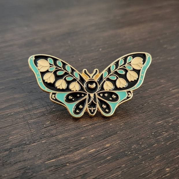 Butterfly-shaped decorative pin on a textured surface