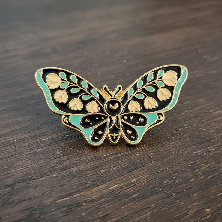 Butterfly-shaped decorative pin on a textured surface