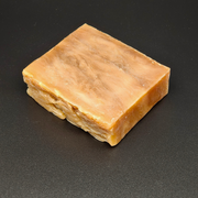 Bar of brown soap on a black background