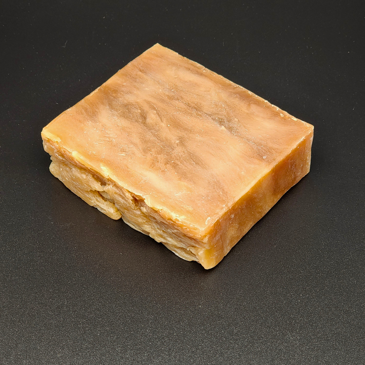 Bar of brown soap on a black background