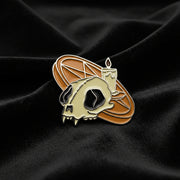 This enamel lapel pin features a vivid orange pentagram altar adorned with a lit candle and a cat skull on a dark fabric background.