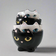 Stack of cat-shaped ceramic bowls with different colored eyes on a white background