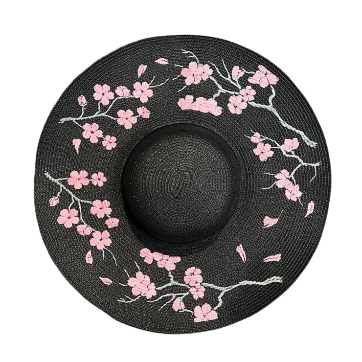 Black straw hat with pink floral embroidery on a white background