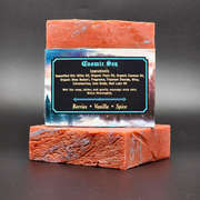 Bar of Cosmic Sea Handmade Bar Soap with a label detailing ingredients on a dark background, scent notes of Berries, Vanilla and Spice.