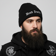 Man wearing a black beanie with 'Dead Inside' text and black jacket with logos on a gray background