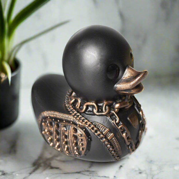 Decorative black rubber duck with bronze decorative elements on a white background