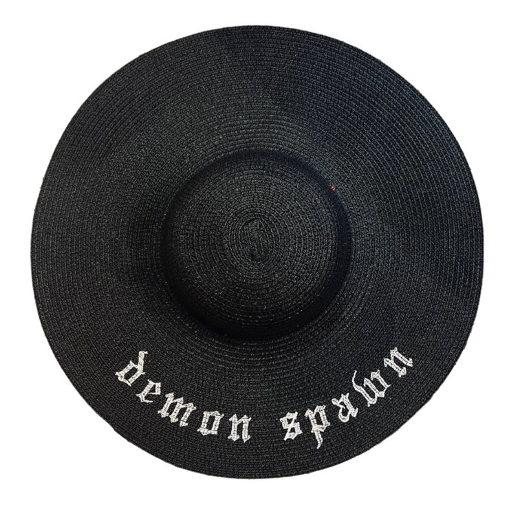 Black straw hat with 'demon spawn' embroidery on a white background