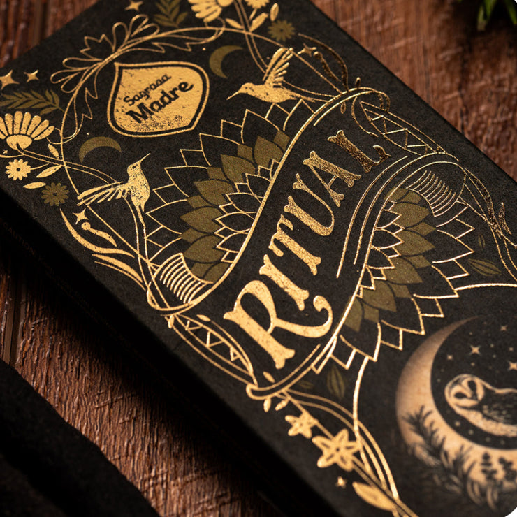 Decorative packaging with gold text and illustrations on a dark background