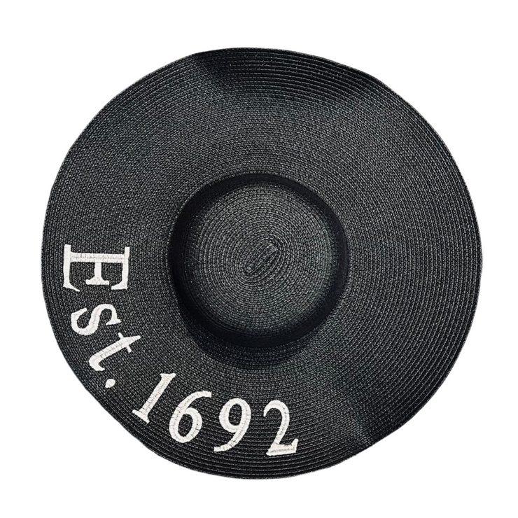 Black straw hat with 'Est. 1692' text on a white background