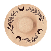 Blush pink sun hat with black leaf and moon designs on a white background