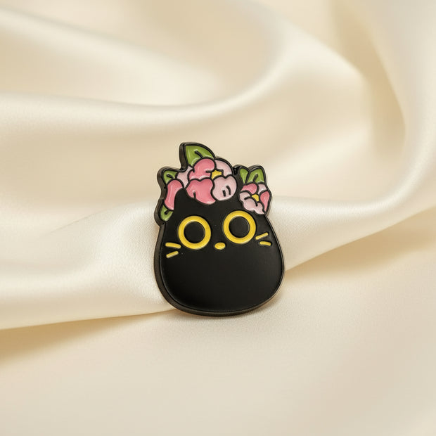 Black cat-shaped pendant with floral designs on a light gray background