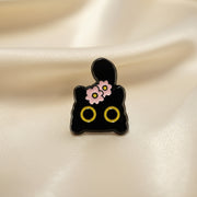 Black cat shaped pin with pink flowers on a light background