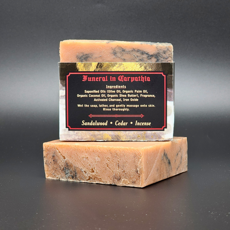 Two stacked soap bars with a label on a dark background