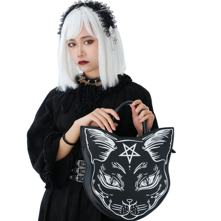 Person holding a black bag with a cat design and pentagram symbol against a white background