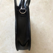 Black handbag on a beige surface