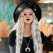 Person with long white hair wearing a black hat and black outfit with a moon pendant.