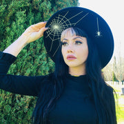 Woman wearing a black hat with spider web design outdoors