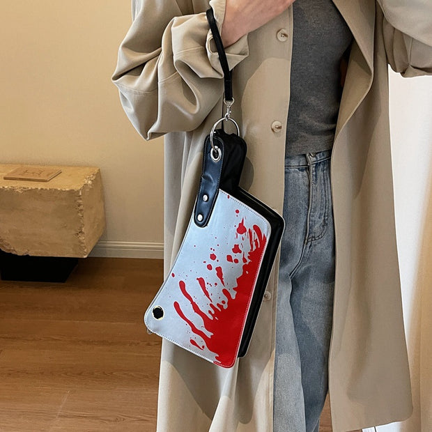 Person holding a bag with a bloody design in a room.