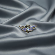 Lightning Bug-shaped pin on a beige background