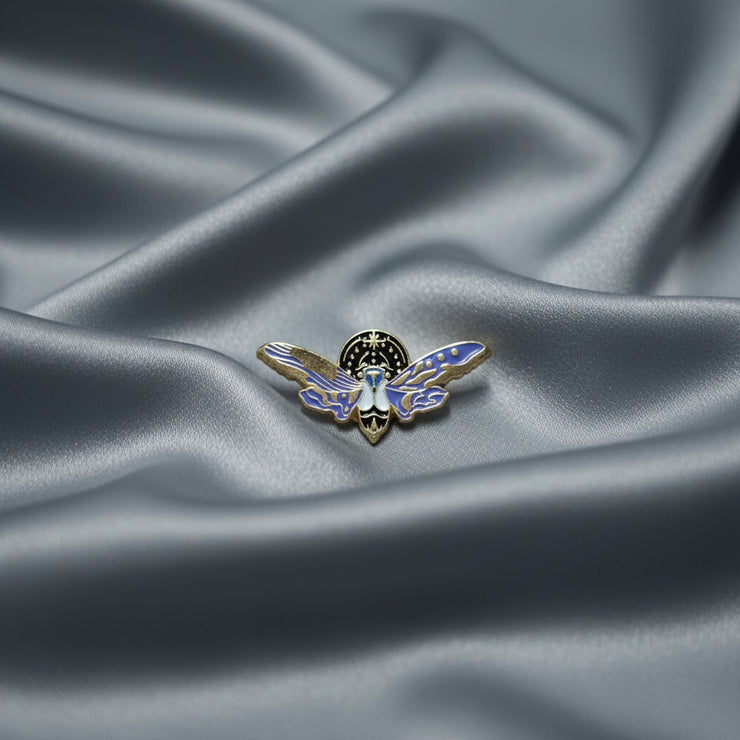 Lightning Bug-shaped pin on a beige background