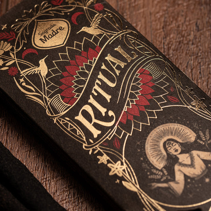 Decorative packaging with 'Ritual' text and intricate designs on a wooden surface