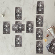 Set of tarot cards on a textured surface with crystals and a crystal ball.