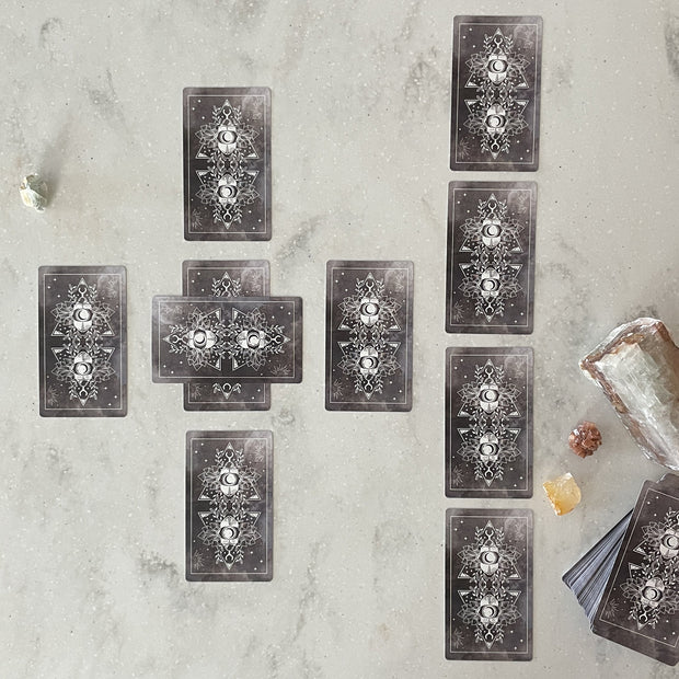 Set of tarot cards on a textured surface with crystals and a crystal ball.