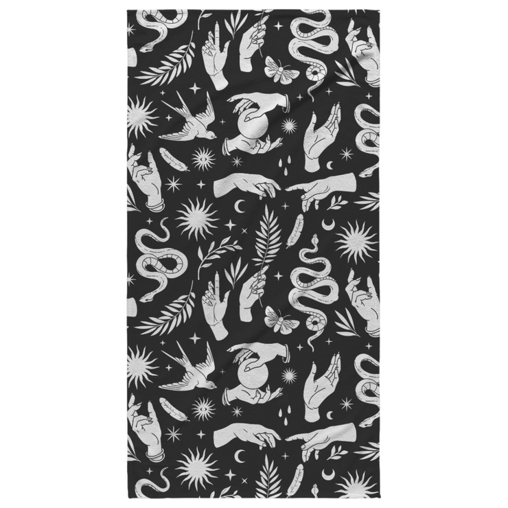 White mystical pattern featuring hands, snakes, suns, moons, crystal balls, swallows, plants, and moths on a black beach towel. Perfect for adding a touch of celestial elegance to any beach or lounging occasion.