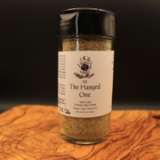 Spice blend jar labeled 'The Hanged One' on a wooden surface with a dark background