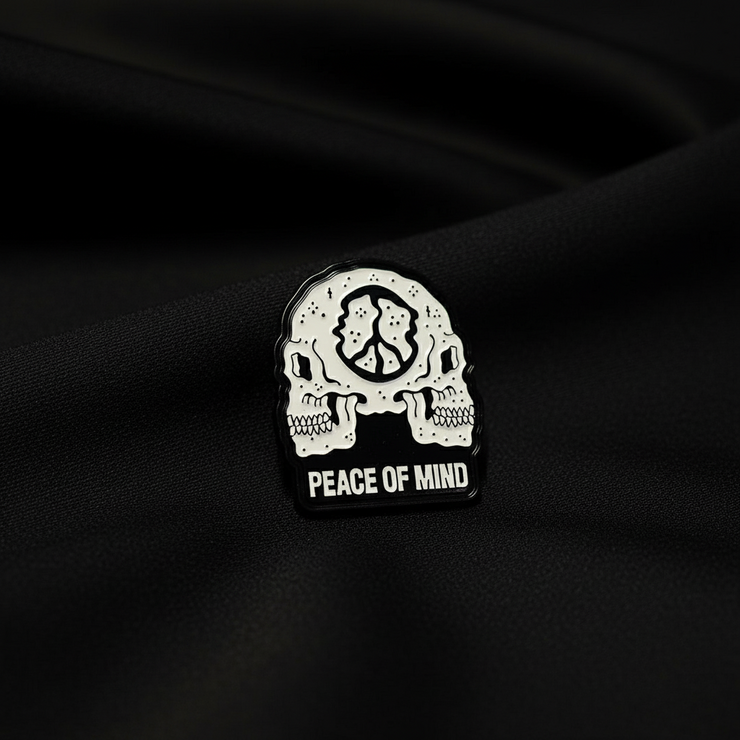 Pin with skull design and 'Peace of Mind' text on a black background