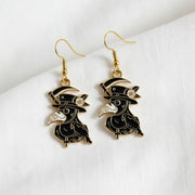 Bird-shaped earrings with gold accents on a light gray background