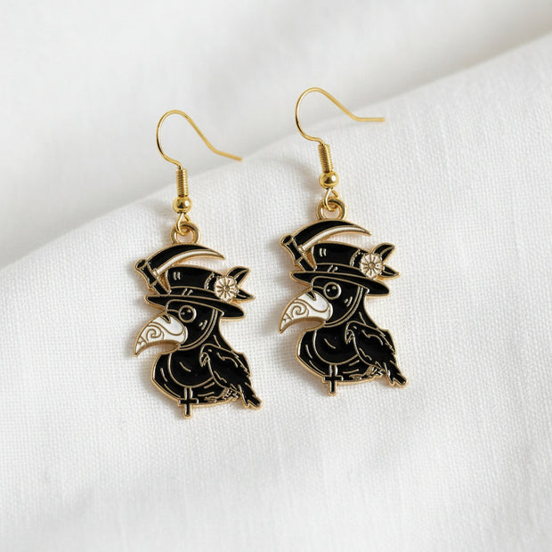 Bird-shaped earrings with gold accents on a light gray background
