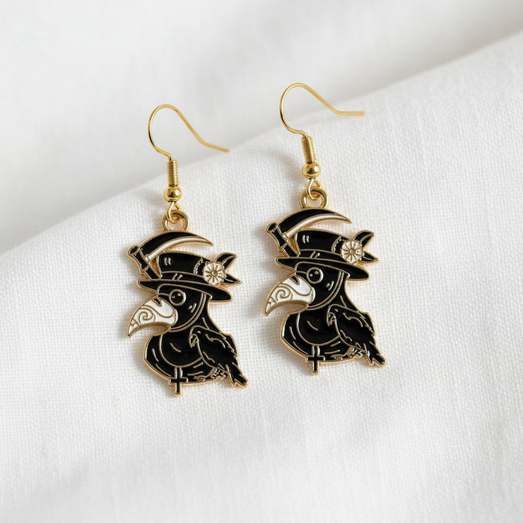 Bird-shaped earrings with gold accents on a light gray background