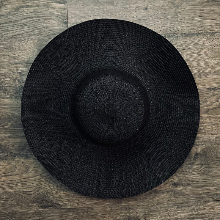 Black straw hat on a wooden surface